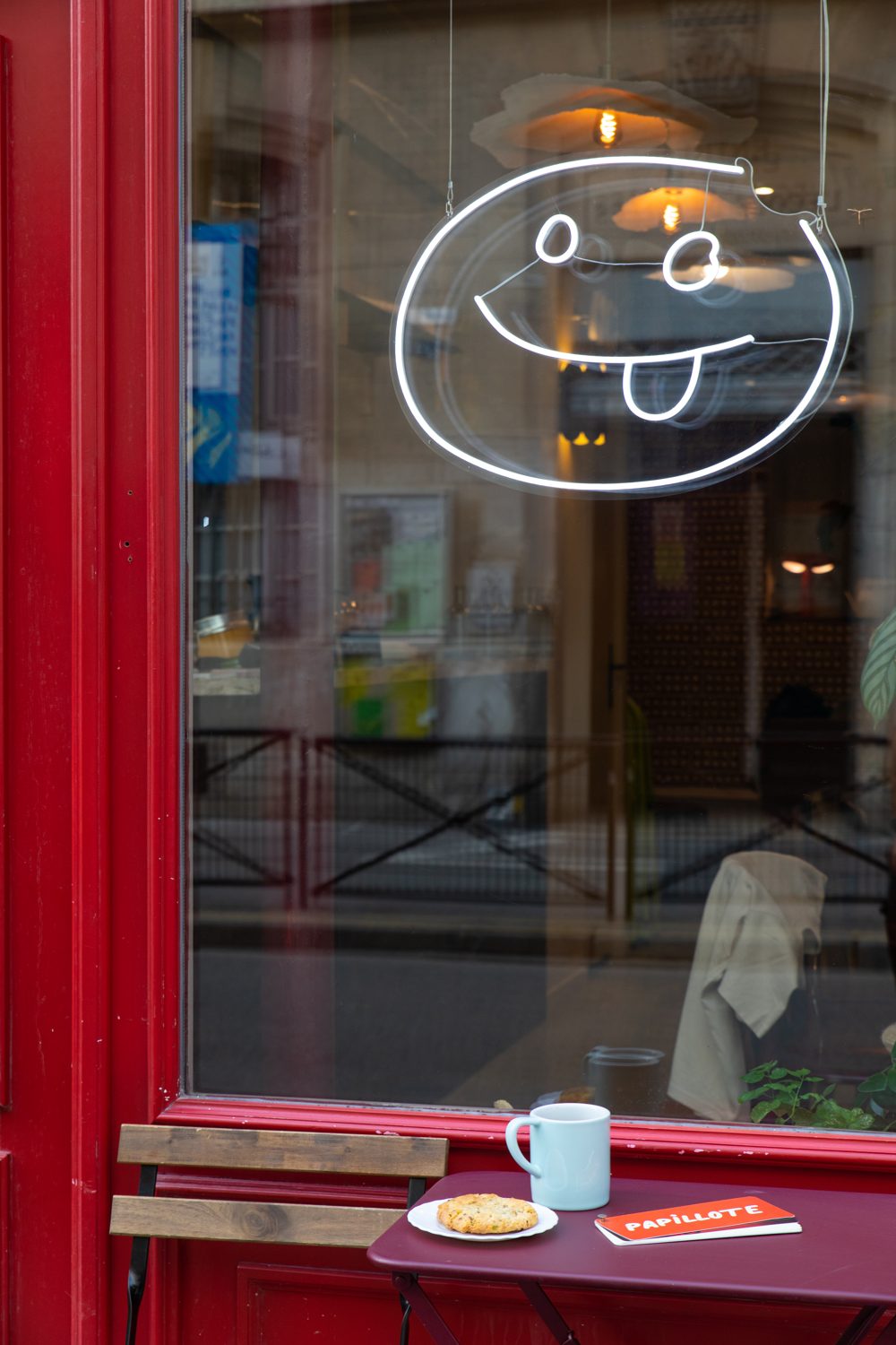 Vitrine rouge de Papillote et néon smiley, ambiance du soir